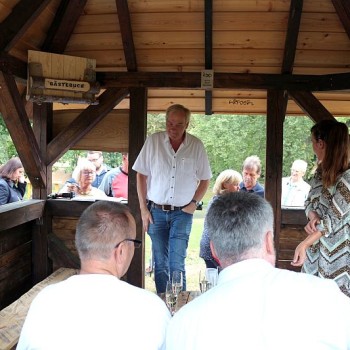 Die Einweihungsgäste nehmen in der Hütte platz